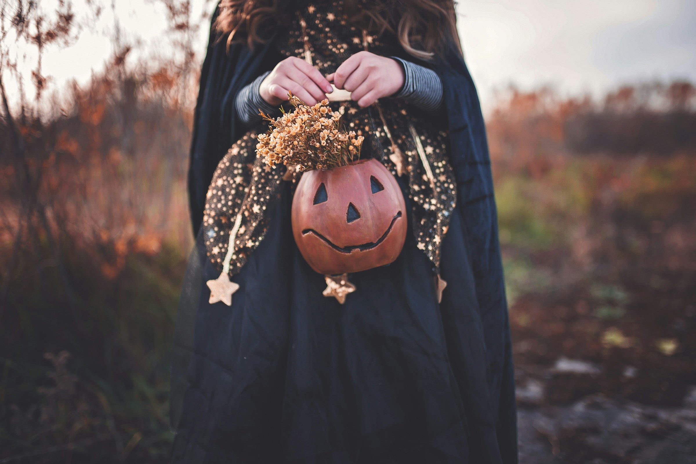 A costumed female figure holding a jack o lantern, photo by Paige Codyb9ae12f2-2b42-4e79-8a9c-427609183a44